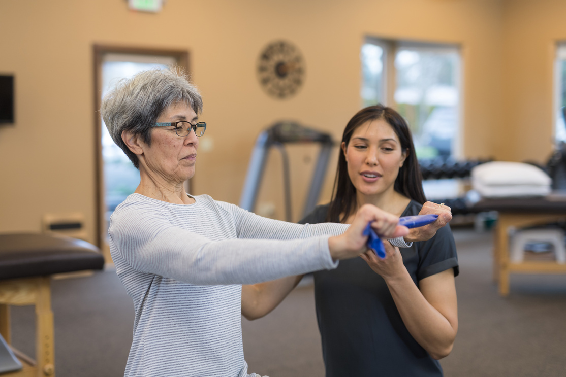 A senior woman works with her occupational therapist