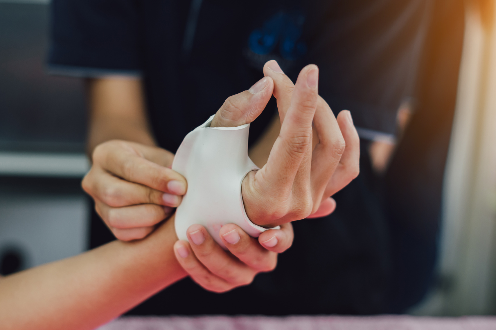 Therapist making asissistive device for immobilize patient finger from rheumatoid arthritis. Splint service for hand injury rehabilitation of occupational