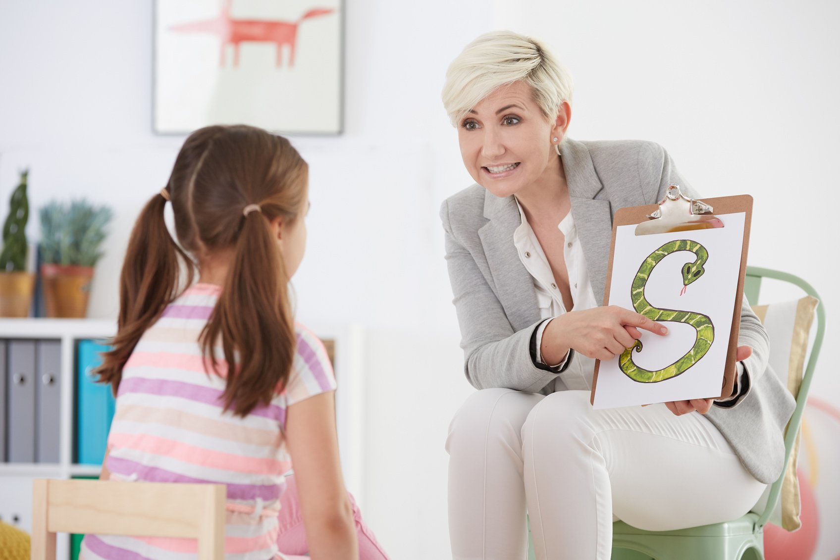 Speech pathologist with young girl